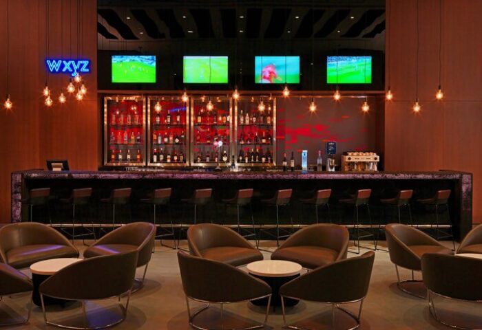 Aloft Me'aisam Dubai's bar. Gay-friendly hotel bar with TVs, drinks, and seating. Modern design, perfect for gay men travelers in Dubai.