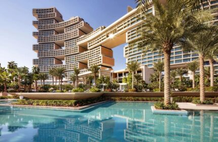 Atlantis The Royal, a gay-friendly hotel. Exterior view showing pool, palm trees, and unique architecture. Ideal for gay travel and luxury stays.