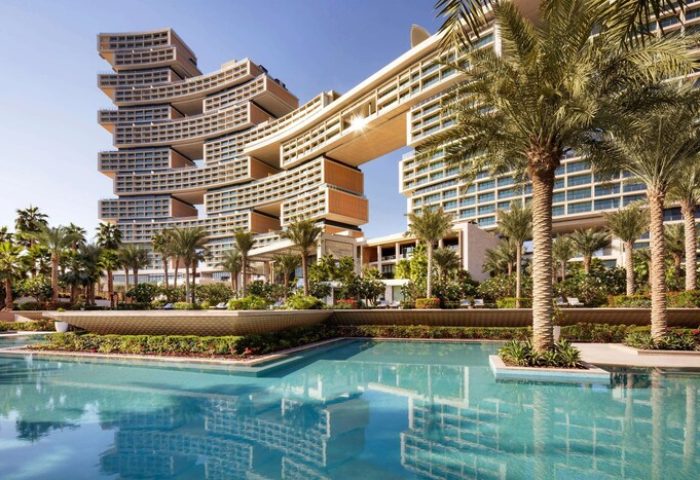 Atlantis The Royal, a gay-friendly hotel. Exterior view showing pool, palm trees, and unique architecture. Ideal for gay travel and luxury stays.