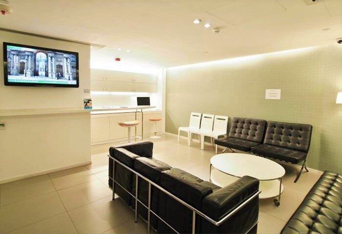 60 West Hotel's stylish lobby. This gay-friendly hotel features modern seating, a TV, and a sleek reception area. Perfect for gay travelers.