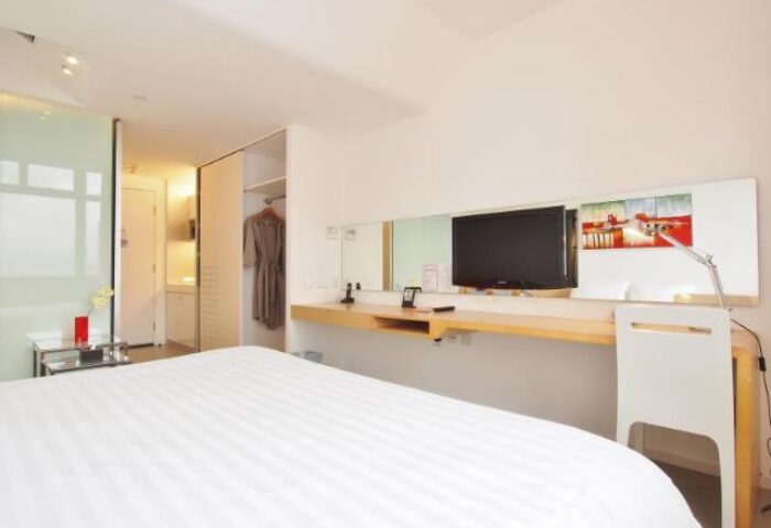 60 West Hotel room. Gay-friendly hotel room with bed, desk, TV, closet, and modern decor. A great choice for gay men travelers.