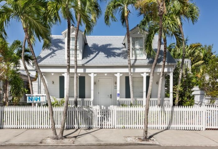 NYAH Key West Gay-Friendly Hotel: Quaint white building with a picket fence and palm trees. Adults-only lodging for gay travelers.
