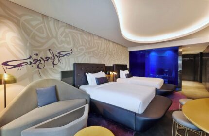 W Dubai - The Palm, gay-friendly hotel room. Two beds, modern design, Arabic calligraphy on the wall. Luxury travel for gay men.
