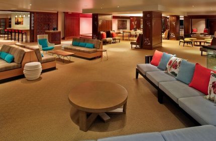 Lounge area at Hilton Hawaiian Village Waikiki Beach Resort, a gay-friendly hotel. Sofas, chairs, and tables offer a relaxing space for guests.