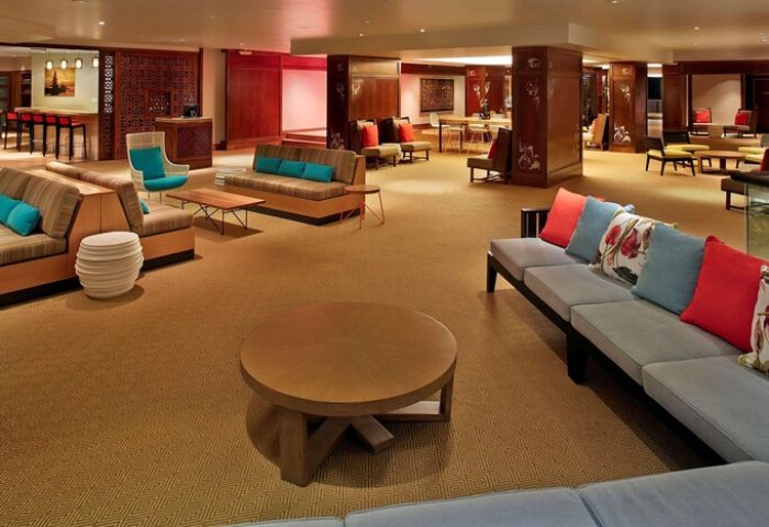 Lounge area at Hilton Hawaiian Village Waikiki Beach Resort, a gay-friendly hotel. Sofas, chairs, and tables offer a relaxing space for guests.