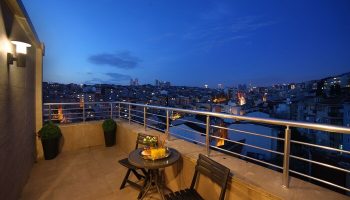 The Fox Hotel's gay-friendly room balcony at night. City view from Istanbul hotel. Table and chairs on the balcony.