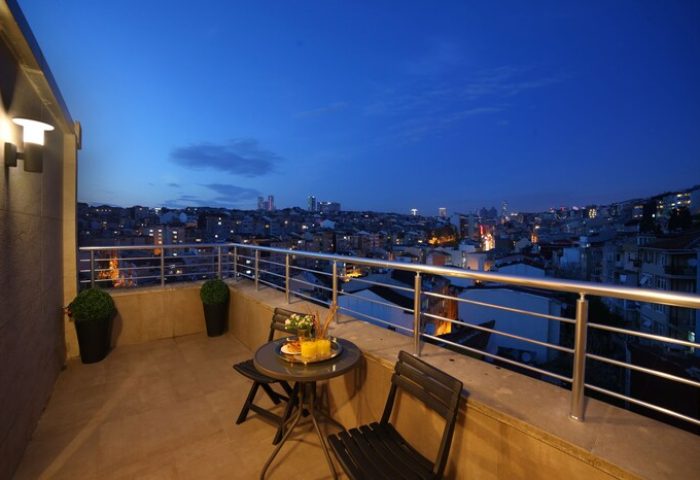 The Fox Hotel's gay-friendly room balcony at night. City view from Istanbul hotel. Table and chairs on the balcony.