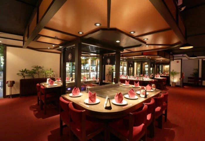 OHANA Waikiki East by OUTRIGGER: Gay-friendly hotel's restaurant. Tables with red napkins, ready for guests. Teppanyaki grill in the center.