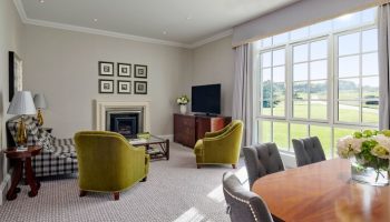 Fairmont St Andrews, Scotland: Gay-friendly hotel living room with golf course view. Elegant interior design, perfect for gay men's travel.