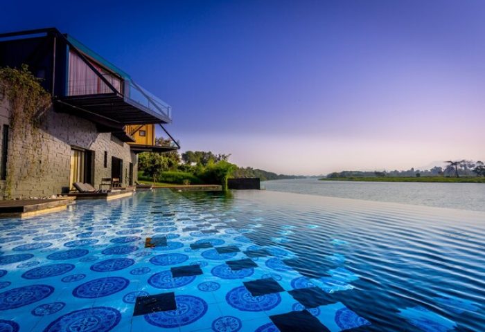 Cross River Kwai gay-friendly hotel. Infinity pool with blue tiles merging into the River Kwai. Serene, luxury travel for gay men.