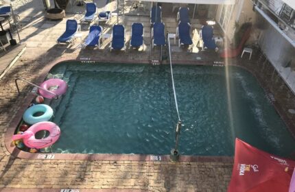 New Orleans gay-friendly hotel pool. Loungers, floaties, and a Stoli umbrella offer a relaxing, inclusive vibe for gay travelers.