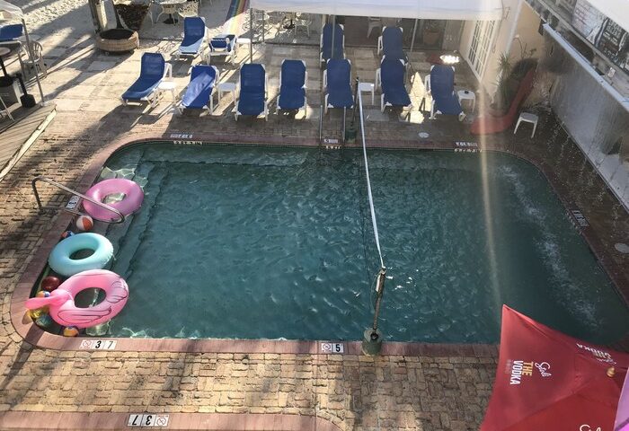 New Orleans gay-friendly hotel pool. Loungers, floaties, and a Stoli umbrella offer a relaxing, inclusive vibe for gay travelers.
