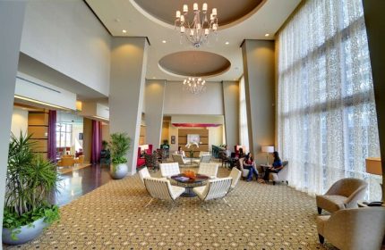 Hampton Inn & Suites Miami/Brickell-Downtown lobby. Gay-friendly hotel with modern design, chandeliers, and seating areas. Great for gay travel.
