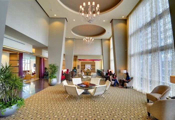 Hampton Inn & Suites Miami/Brickell-Downtown lobby. Gay-friendly hotel with modern design, chandeliers, and seating areas. Great for gay travel.