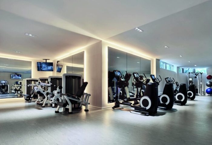The Miami Beach EDITION's gym. This gay-friendly hotel features modern fitness equipment and mirrored walls, perfect for a workout during your stay.