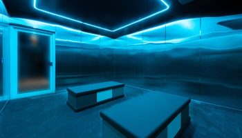 The Standard Miami gay-friendly hotel sauna. Blue neon lights illuminate metal walls and benches. A modern, sleek design for gay travelers.