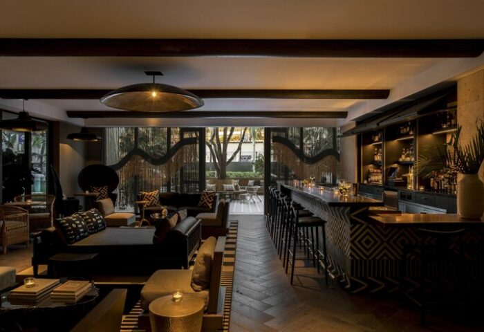 Kimpton Angler's Hotel bar and lounge area. Gay-friendly hotel with stylish decor, dark wood accents, and outdoor seating. Miami Beach gay travel.