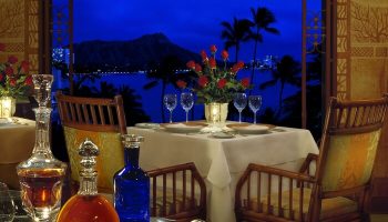 Halekulani Hotel dining table at night with Diamond Head view. Gay-friendly hotel for gay men travelers. Fine dining experience.