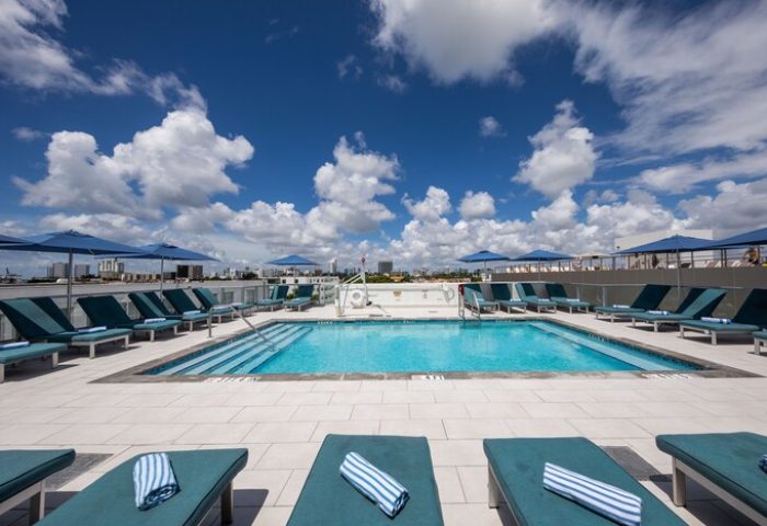 President Hotel's rooftop pool. Gay-friendly hotel with lounge chairs, umbrellas, and city views. Perfect for gay travel and relaxation.