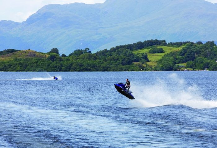 Cameron House on Loch Lomond: Water sports at this gay-friendly hotel. A man rides a jet ski on the loch, with mountains in the background.