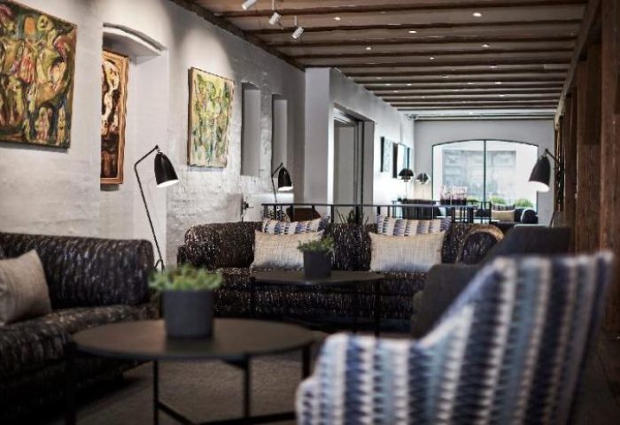 Lobby at 71 Nyhavn Hotel, a gay-friendly, pet-friendly hotel. Seating area with sofas, chairs, tables, and artwork. Interior design.