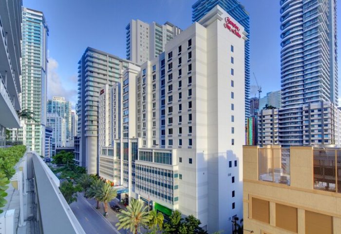 Hampton Inn & Suites Miami/Brickell-Downtown, a gay-friendly hotel. High-rise building with palm trees in Miami's Brickell neighborhood.