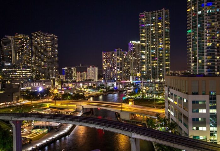 Downtown Brickell-Port of Miami at night. View from a gay-friendly hotel. Cityscape with illuminated buildings and waterways.