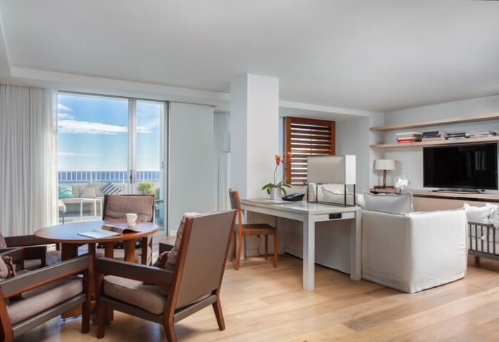 Modern Honolulu Hilton Vacation Club suite living area. Ocean view, desk, TV. Gay-friendly hotel room interior.