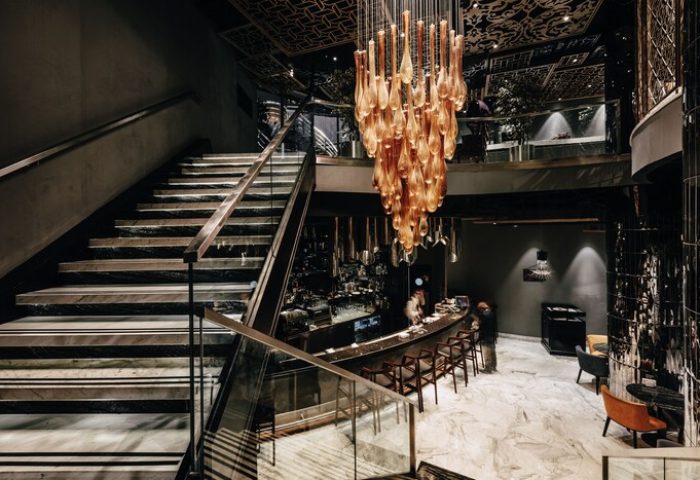 Elysium Taksim Hotel interior. Stairs lead to a bar under a chandelier. Gay-friendly hotel in Istanbul, Turkey. Upscale travel for gay men.