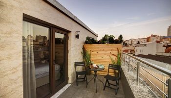 The Fox Hotel's gay-friendly balcony view. Chairs and table on a private balcony. Gay travel accommodations. Hotel room with outdoor space.