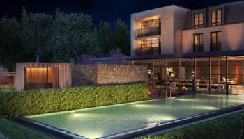 Schloss Roxburghe Hotel's gay-friendly outdoor pool at night. Modern building with sauna, lounge chairs, and starry sky. Luxury gay travel.