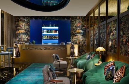 W Dubai - Mina Seyahi gay-friendly hotel bar. Stylish seating, jungle print wallpaper, and a well-stocked bar. A luxurious travel destination.