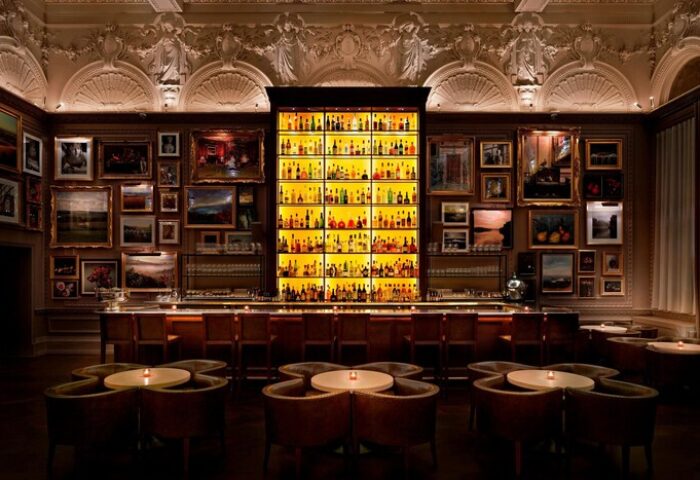 The London EDITION gay-friendly hotel bar. A stylish bar with a large liquor selection & art-covered walls. Upscale, luxurious interior.