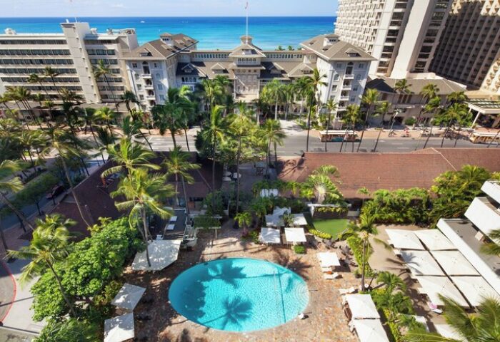 Sheraton Princess Kaiulani, a gay-friendly hotel. Aerial view of the pool, palm trees, and Waikiki beach. Perfect for gay travel in Honolulu.
