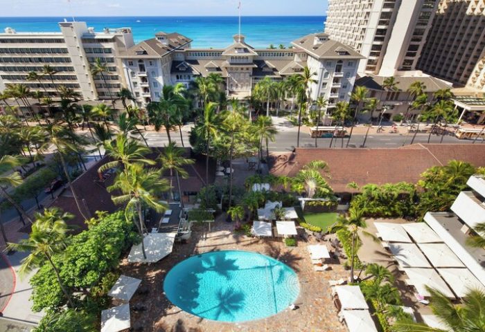 Sheraton Princess Kaiulani, a gay-friendly hotel. Aerial view of the pool, palm trees, and Waikiki beach. Perfect for gay travel in Honolulu.