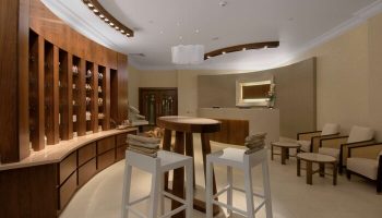 Fairmont St Andrews, Scotland: Gay-friendly hotel spa reception area with curved wood display, stools, and seating. Luxury travel for gay men.