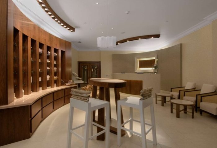 Fairmont St Andrews, Scotland: Gay-friendly hotel spa reception area with curved wood display, stools, and seating. Luxury travel for gay men.