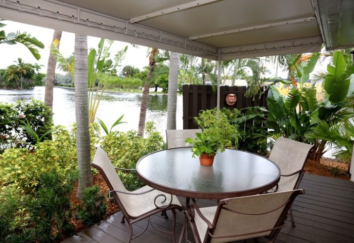 The Cabanas Guesthouse: Gay-friendly hotel patio with table, chairs, and lush tropical plants. A relaxing outdoor space at this gay men's resort.