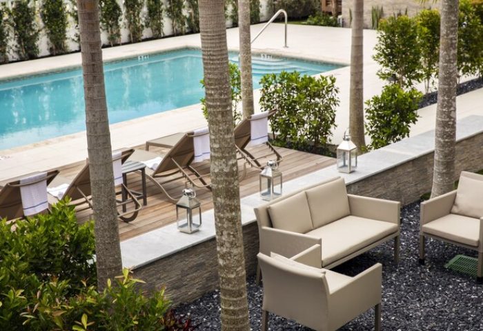 Elita Hotel's gay-friendly pool area. Loungers, seating, and palm trees offer a relaxing space. Perfect for gay men's travel and vacation.