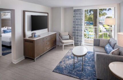 The Reach Key West, Curio Collection by Hilton gay-friendly hotel room. Balcony view, TV, sofa, and bedroom. Gay travel to Key West.