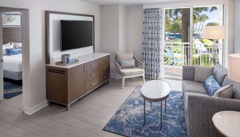 The Reach Key West, Curio Collection by Hilton gay-friendly hotel room. Balcony view, TV, sofa, and bedroom. Gay travel to Key West.