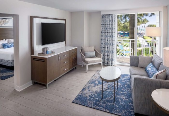 The Reach Key West, Curio Collection by Hilton gay-friendly hotel room. Balcony view, TV, sofa, and bedroom. Gay travel to Key West.