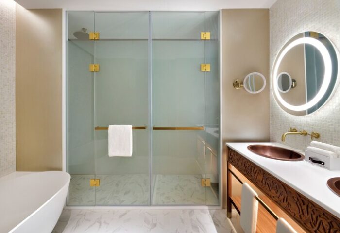 Hotel Indigo Dubai Downtown gay-friendly bathroom. Walk-in shower, copper sink, illuminated mirror. Upscale hotel for gay travelers.