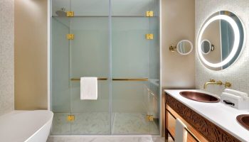 Hotel Indigo Dubai Downtown gay-friendly bathroom. Walk-in shower, copper sink, illuminated mirror. Upscale hotel for gay travelers.