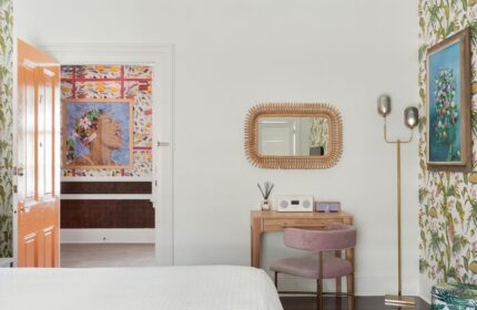 Marrero's Guest Mansion gay-friendly hotel room. Desk with mirror, chair, lamp, and art. Colorful wallpaper. Key West gay travel advice.