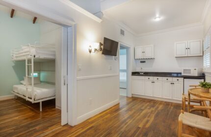 NYAH Key West gay-friendly hotel room with bunk beds. Adult's only lodging with a kitchenette, table, and chairs. Interior view.
