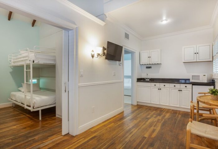 NYAH Key West gay-friendly hotel room with bunk beds. Adult's only lodging with a kitchenette, table, and chairs. Interior view.