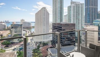 EAST Miami gay-friendly hotel balcony view. High-rise buildings, city streets, and Biscayne Bay are visible. Modern design, perfect for gay travelers.