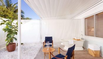 The Standard Miami gay-friendly hotel room. Outdoor patio with bathtub, chairs, and table. Perfect for gay travel & relaxation.