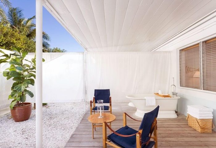 The Standard Miami gay-friendly hotel room. Outdoor patio with bathtub, chairs, and table. Perfect for gay travel & relaxation.